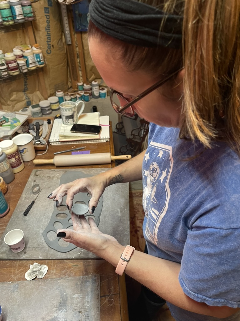 A senior's hand painting part of a collaborative tree artwork